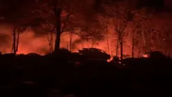 Flames glow in the background during a five-alarm fire in Smithfield, RI, on Monday, Nov. 15, 2021.