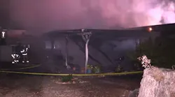 Smoke rises from a Santee, CA, home that burned in a suspected arson fire on Saturday, Nov. 6, 2021.