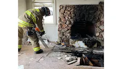 A firefighter uses a chainsaw to cut through the floor as crews extinguish a fire that extended from an unattended fireplace in a Fresno, CA, home on Tuesday, Nov. 16, 2021.