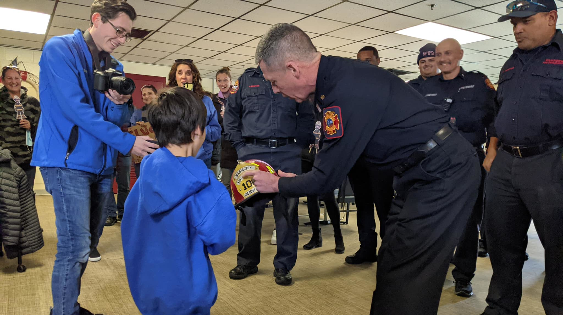 Wilmington Fire Chief John Looney presents Elliott Slocum with a firefighter's helmet.