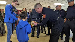 Wilmington Fire Chief John Looney presents Elliott Slocum with a firefighter's helmet.