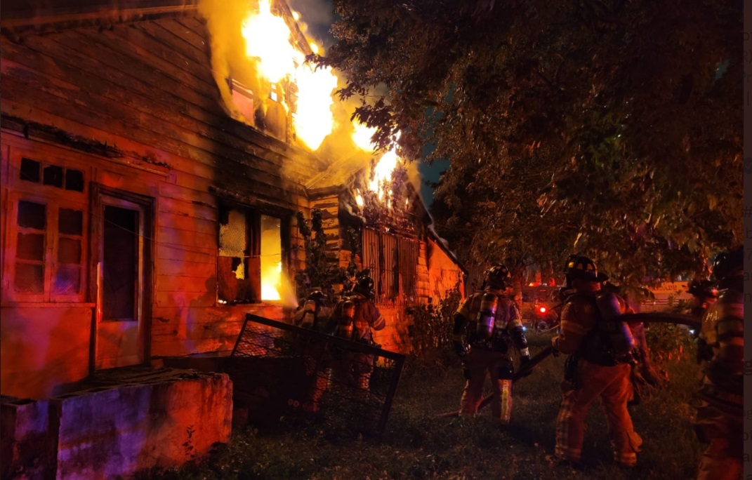 Firefighters work to control fire in a condemned home.
