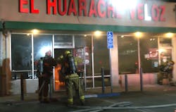 LA City firefighters prepare to enter a strip mall restaurant to extinguish an arson fire