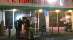 LA City firefighters prepare to enter a strip mall restaurant to extinguish an arson fire