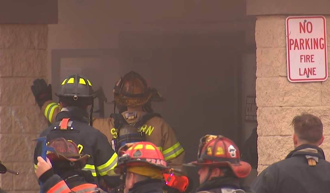 Firefighters battle fire as it runs between floors of a commercial building on Nov. 28, 2021