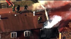 Saint Louis firefighters open up the roof during an apartment fire. Saint Louis firefighters open up the roof during an apartment fire.