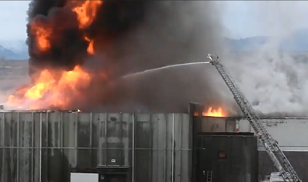Firefighters use aerial device to control a commercial fire in Tonasket on Nov. 26, 2021