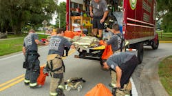 Pasco County, FL, Fire Rescue (PCFR) members swap turnout gear that they wore for a structure fire for a clean set of gear that a decon technician brought to the scene. Pasco County, FL, Fire Rescue (PCFR) members swap turnout gear that they wore for a structure fire for a clean set of gear that a decon technician brought to the scene.