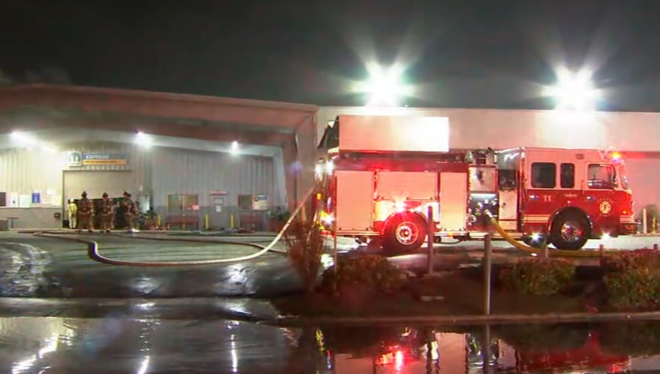 Fresno firefighters survey conditions during an auto dealership fire.