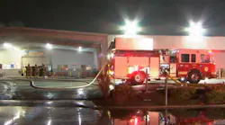 Fresno firefighters survey conditions during an auto dealership fire.