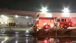 Fresno firefighters survey conditions during an auto dealership fire.