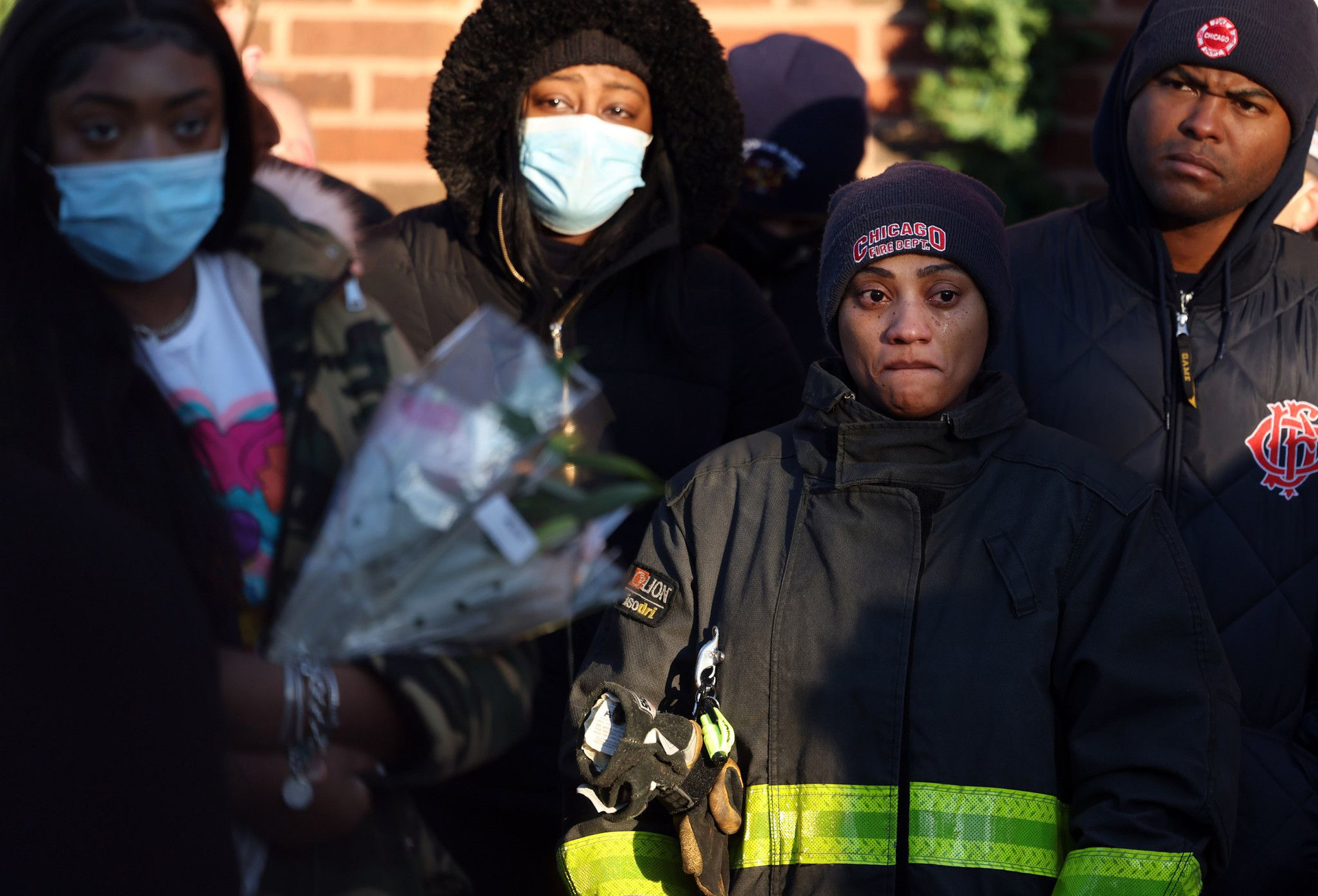 Firefighters and family members gather during a prayer vigil for Chicago firefighter Mashawn Plummer and resident Eladio Luis Gomez.