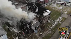 Smoke pushes from the second floor as firefighters work to control fire in a Canton home.