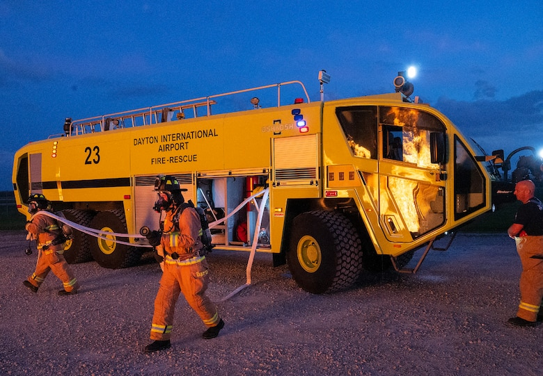 Dayton International Airport firefighters pull hoses from their crash truck Oct. 5, 2021, to advance on a live training fire at Wright-Patterson Air Force Base, Ohio.