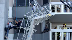 Firefighters prepare to lower a worker to safety after their scaffold collapsed.