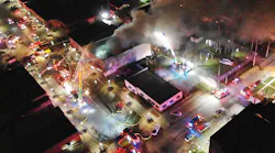 Firefighters use multiple aerial devices to control fire in a downtown building.