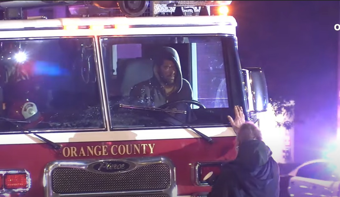 A citizen encourages the driver of a stolen fire truck to give up.