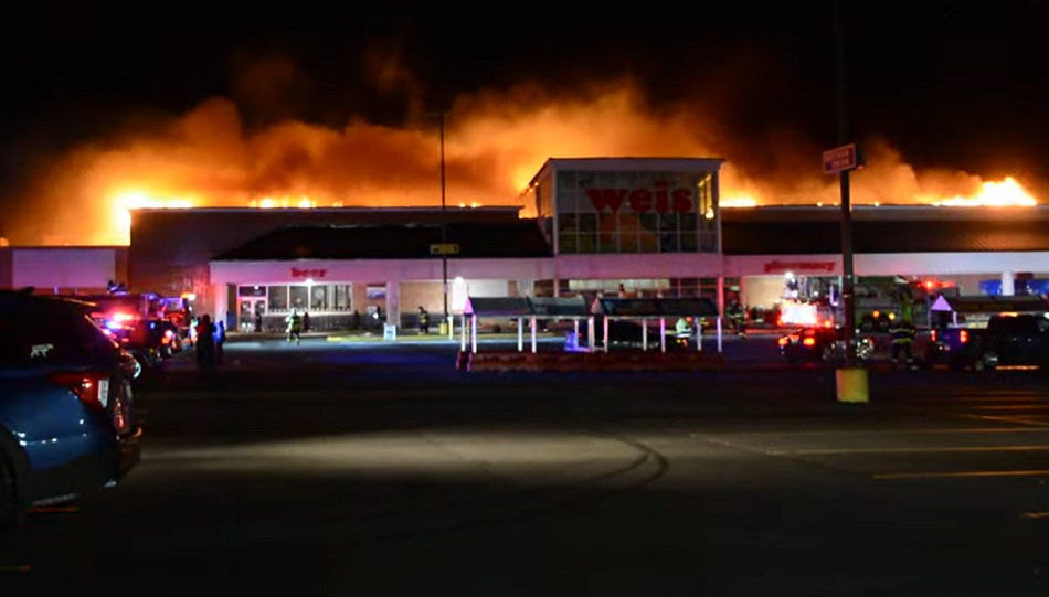 Fire spreads across the roof of a grocery store in West Hazleton.
