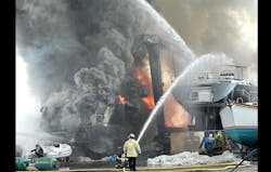 Firefighters use handlines, marine and aerial streams to control fire involving two large vessels. Firefighters use handlines, marine and aerial streams to control fire involving two large vessels.