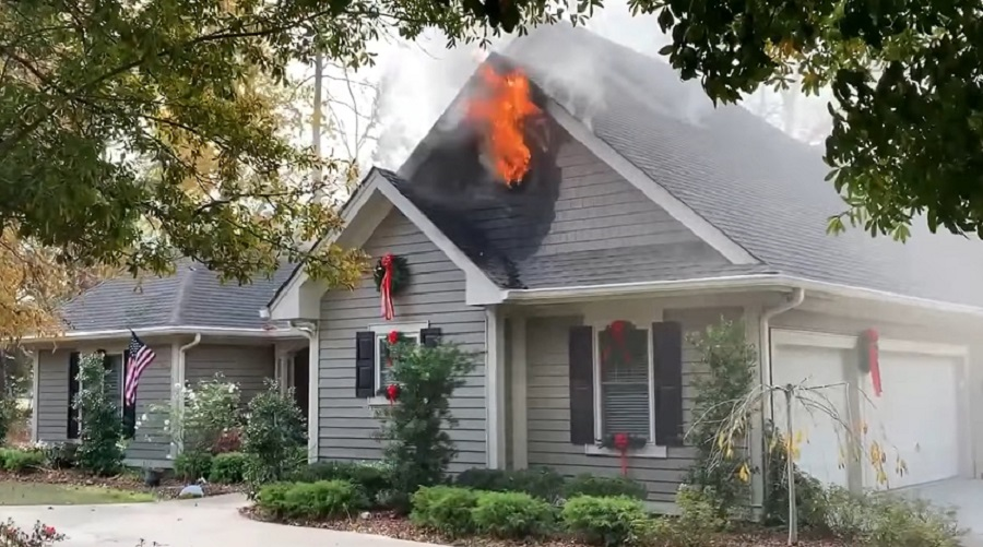 Fire vents out the gable end of the structure fire prior to firefighter arrival.