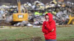 A woman walks away from the debris at the Mayfield Consumer Products Candle Factory where rescue crews were combing through the rubble Saturday.