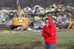 A woman walks away from the debris at the Mayfield Consumer Products Candle Factory where rescue crews were combing through the rubble Saturday. A woman walks away from the debris at the Mayfield Consumer Products Candle Factory where rescue crews were combing through the rubble Saturday.