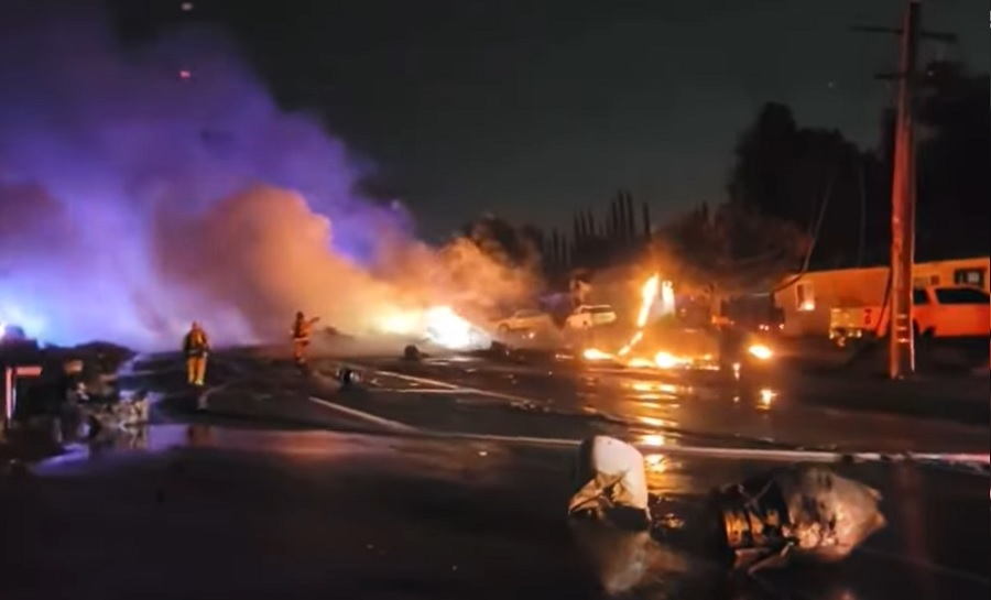 Firefighters work to extinguish the flames after an aircraft crash in El Cajon.