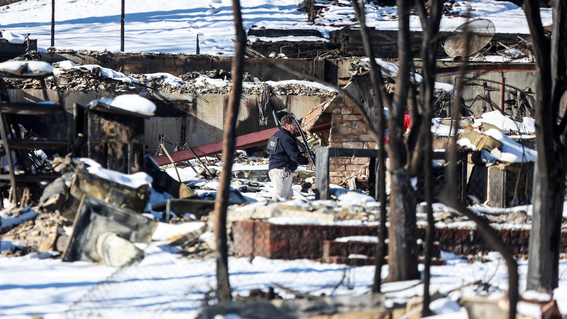 A police officer walks through a Louisville neighborhood decimated by the Marshall fire.