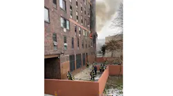 FDNY firefighters rescue person atop a portable ladder at a deadly Bronx apartment fire Sunday morning.