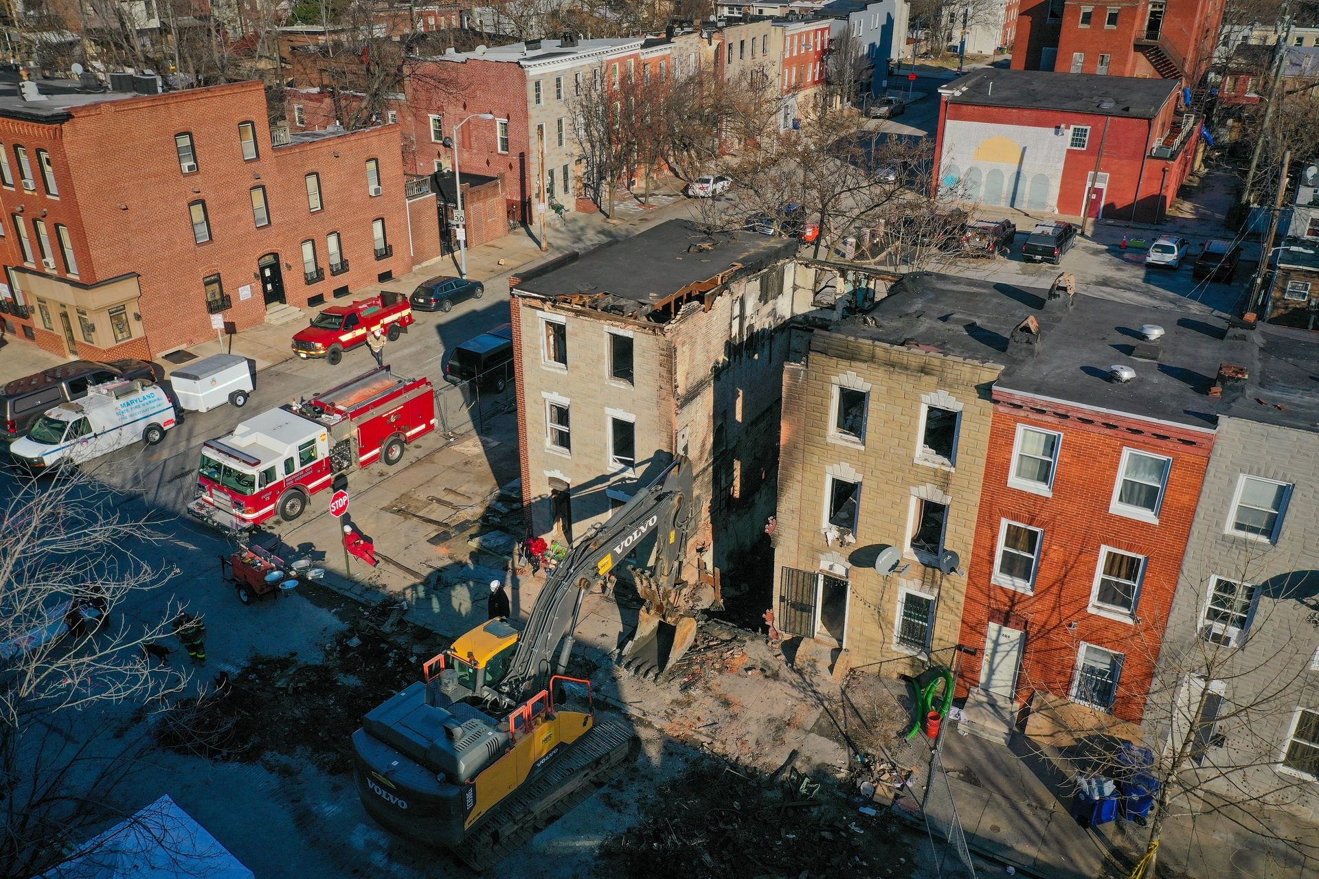 An excavator sits the remains of a vacant row house on Stricker Street as ATF investigators search for the cause of a fire that resulted in the death of three Baltimore City firefighters Monday morning.