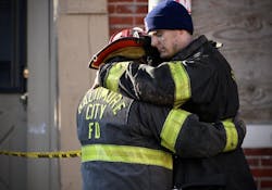 Firefighters hug at the scene of the South Stricker rowhome fire Monday morning. Firefighters hug at the scene of the South Stricker rowhome fire Monday morning.