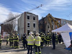 Firefighters watch as crews work to recover the body of a firefighter killed in the collapse. Firefighters watch as crews work to recover the body of a firefighter killed in the collapse.