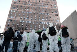 Clean-up and recovery workers gather in front of a Bronx apartment building a day after a fire swept through the complex. Clean-up and recovery workers gather in front of a Bronx apartment building a day after a fire swept through the complex.
