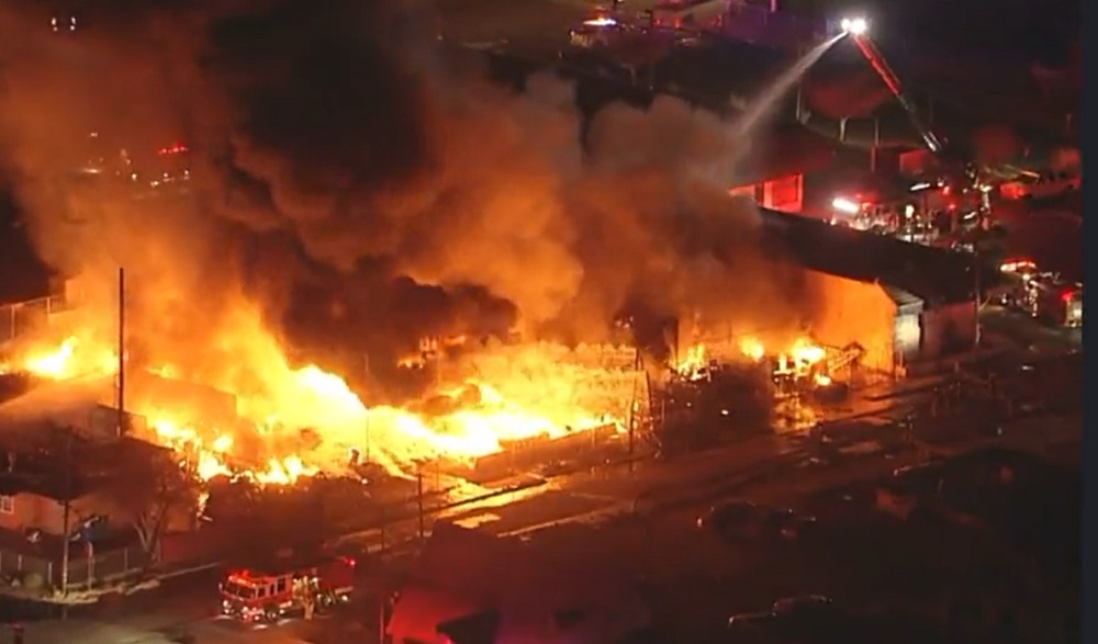 Firefighters use multiple aerial devices to control a massive fire in Adelanto.