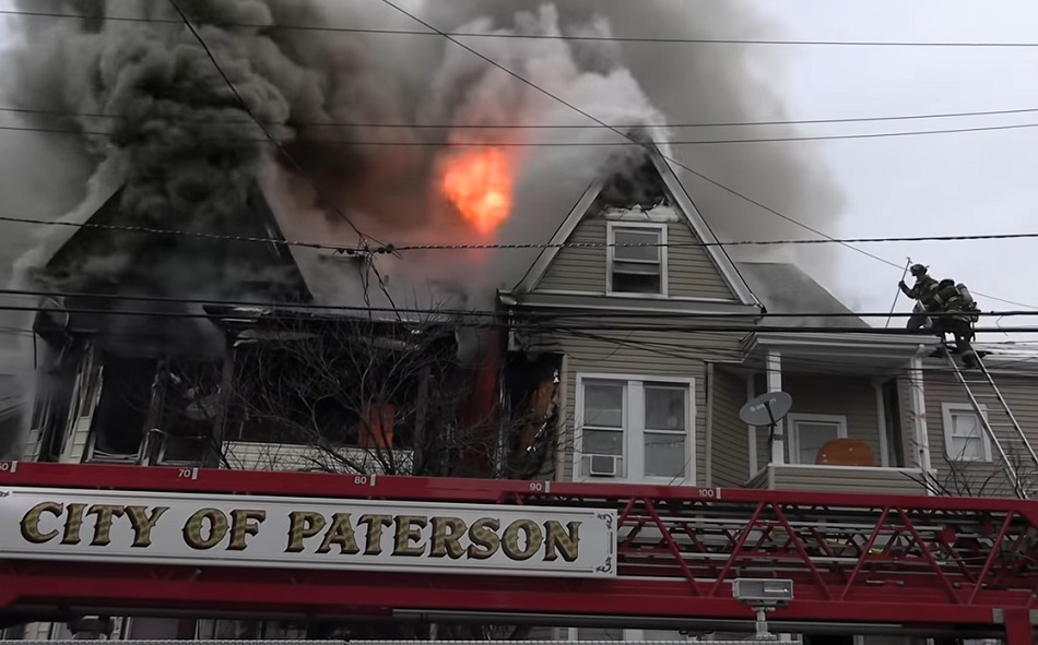 Paterson firefighters work to control heavy fire and smoke conditions during a residential fire.