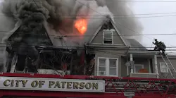 Paterson firefighters work to control heavy fire and smoke conditions during a residential fire.