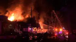 Firefighters battled heavy flames that destroyed a home and sent four occupants to the hospital in West Deptford.