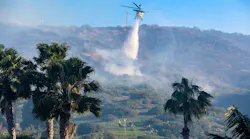 A helicopter makes a water drop on on the Emerald fire burning near homes in the hills above Emerald Bay and Irvine Cove in Laguna Beach on Thursday.