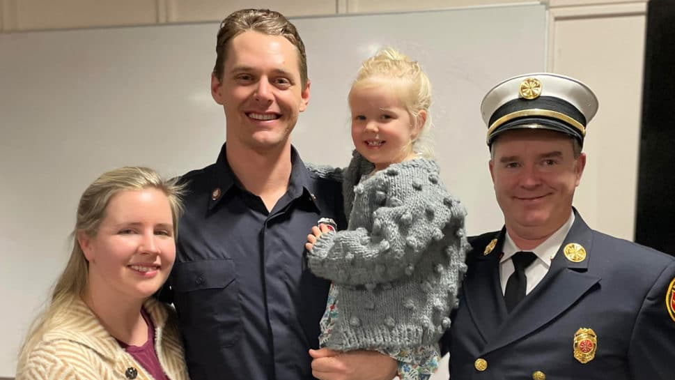 Firefighter Justin Haley, with his wife and daughter, along with West Newbury Fire Chief Michael Dwyer.