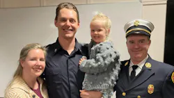 Firefighter Justin Haley, with his wife and daughter, along with West Newbury Fire Chief Michael Dwyer.