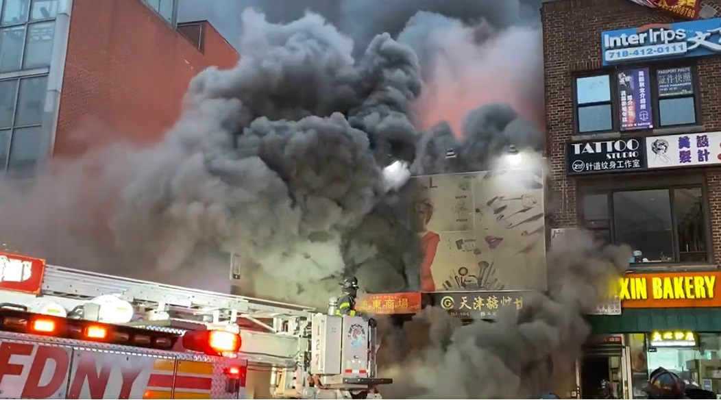 FDNY crews are battling a five-alarm fire in Flushing, Queens involving a commercial building.