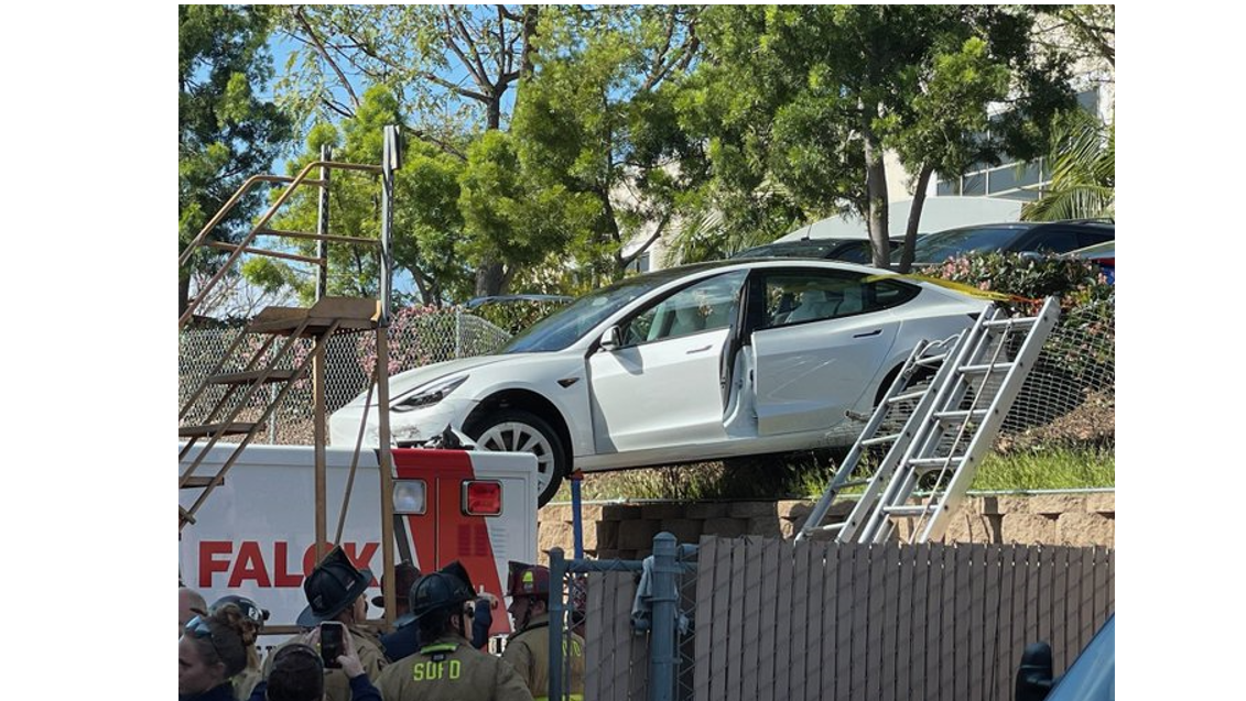 The Tesla went through a fence and landed on a back of a Falck ambulance that was parked in a parking lot.