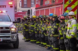 Baltimore City firefighters salute as an ambulance carries the body of Lt. Paul Butrim from the scene of a vacant row house fire on S. Stricker Street. Four firefighters were trapped in a collapse while fighting the fire Monday morning. Three have died and a fourth is in critical condition.