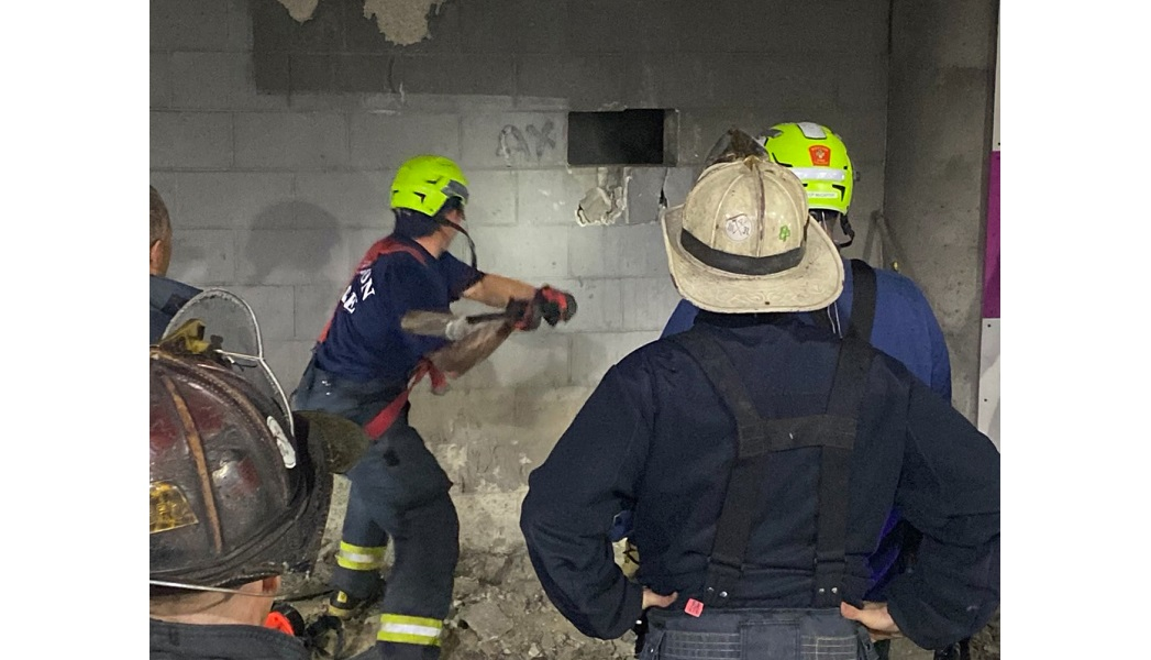 Boston firefighters work to rescue a man who fell and was trapped between two walls at a commuter rail station.
