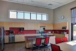The performance requirements of a fire department kitchen and dining room needn&rsquo;t exclude upscale design. Both effects result here from the integration of a warm stain color into the polished concrete, a red-tile backsplash and stainless steel countertops.