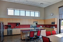 The performance requirements of a fire department kitchen and dining room needn’t exclude upscale design. Both effects result here from the integration of a warm stain color into the polished concrete, a red-tile backsplash and stainless steel countertops. The performance requirements of a fire department kitchen and dining room needn’t exclude upscale design. Both effects result here from the integration of a warm stain color into the polished concrete, a red-tile backsplash and stainless steel countertops.