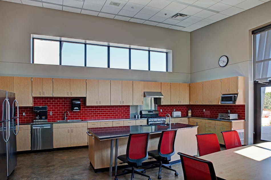 The performance requirements of a fire department kitchen and dining room needn&rsquo;t exclude upscale design. Both effects result here from the integration of a warm stain color into the polished concrete, a red-tile backsplash and stainless steel countertops.