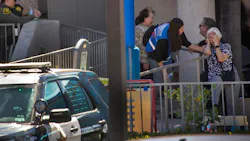 A grief counselor comforts a parishioner after a person opened fire during a church service, killing one person and critically injuring four others.