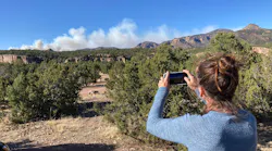 CRIPPLE CREEK, COLORADO - MAY 12: Climber Michelle Kranz takes a photo of billowing smoke from a wildfire burning north of her location along Shelf Road, west of Cripple Creek, Colorado, on May 12, 2022.