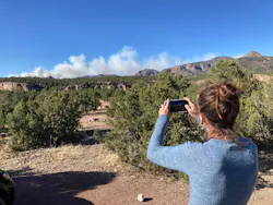CRIPPLE CREEK, COLORADO - MAY 12: Climber Michelle Kranz takes a photo of billowing smoke from a wildfire burning north of her location along Shelf Road, west of Cripple Creek, Colorado, on May 12, 2022.